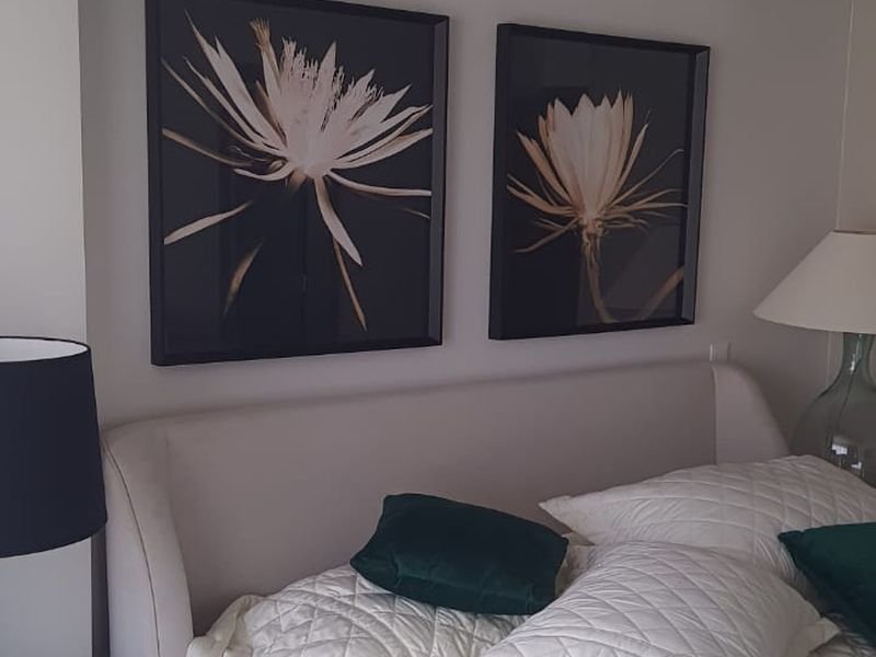Quadros alinhados sobre a cabeceira da cama