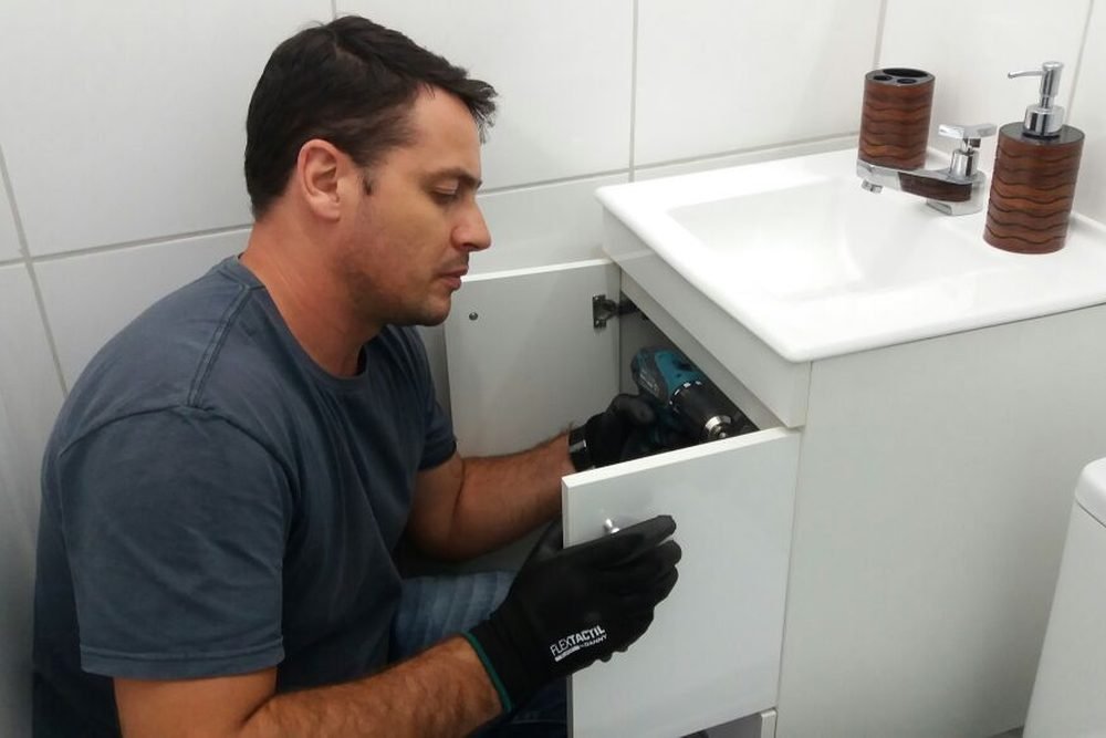 Montador da Monta Tudo Móveis montando um gabinete de banheiro com parafusadeira